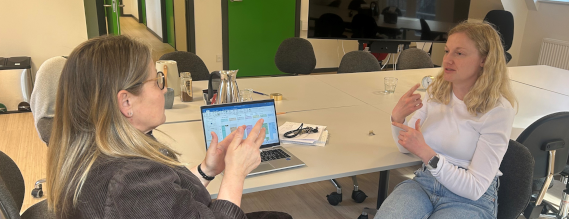 To kvinde sidder ved et bord og taler tegnsprog